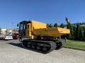 A 2022 TerraMac Tracked Dump with a yellow bed and black tracks positioned for operation