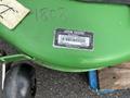 A green John Deere 1585 Terrain Cut mower featuring a serial number label attached to its side