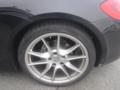 Close-up of the rear wheel of a 2016 Porsche Boxster showing a silver alloy rim and a black tire with visible brake calipers