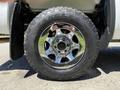 Close-up of a shiny chrome wheel and tire on a 2016 GMC Sierra 1500 featuring a rugged Goodyear Wrangler tire tread