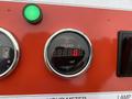 Close-up of a digital hour meter displaying 0000.0 hours on a red panel with a green indicator light and additional dials