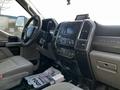 Interior of a 2018 Ford F-550 featuring a steering wheel dashboard control panel and seats with grey upholstery