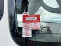 A red and white vehicle inspection sticker displayed on the window of a 2008 International 7500 truck showing various months and the year 2025