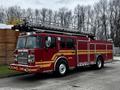 A red 2009 Spartan Gladiator fire truck with a silver ladder on top and multiple compartments on the sides