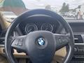Interior view of a 2009 BMW X5 focusing on the steering wheel with the BMW logo and control buttons visible