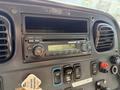 A close-up of the dashboard of a 2015 Freightliner M2 106 featuring a radio and various control buttons