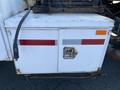 A storage compartment on a 2007 International 7300 featuring a silver latch a red stripe and a reflective strip on the front