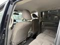 Interior view of a 2014 Honda Odyssey showing two front seats and a spacious rear seating area with grey upholstery and armrests