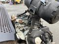 Close-up of a 2014 Vermeer Corporation Sweep Stump Cutter's engine components showing various metal parts and a large black air filter on top