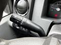 A close-up of the control stalk inside a 2011 Ford F-550 featuring symbols for high beams windshield wipers and turn signals