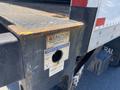 A rusted section of a 2015 Ford F-450 SD truck bed showing a caution sign and an operation instructions label with a hole for securing items