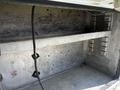 A 2004 Freightliner M2 truck's empty cargo area showing metal shelves and a clean interior surface with no items inside
