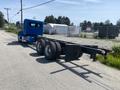 A blue 2008 Peterbilt 340 truck with a spacious cab and large wheels, featuring a flatbed and a chrome exhaust pipe