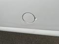 A white 2013 Chevrolet Express with a small dent and scratch marks near the fuel cap area