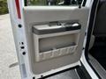 Interior door panel of a 2009 Ford F-550 featuring a large handle and a storage compartment with several slots for items