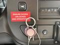 A key holder with a red circular label that says FIRE attached to a panel with buttons for door unlocking and controls in a 2020 Chevrolet Express dashboard