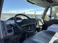 Interior view of a 2008 International 7500 truck showing the steering wheel dashboard and driver's seat with controls and storage compartments visible