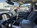 Interior view of a 2015 RAM 1500 showing the front seats dashboard and center console with storage compartments