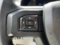 Close-up of a black steering wheel control panel featuring directional buttons and an OK button on a 2017 Ford F-250 SD