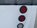 The rear tail lights of a 2018 Chevrolet Express featuring three circular lights with two red lights on top and one white light on the bottom