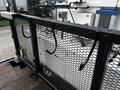A 2008 International 7500 truck with a black metal mesh bed and hooks attached to the sides for securing cargo