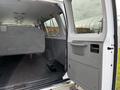 A 2014 Ford Econoline with its rear door open revealing a spacious interior and grey upholstery