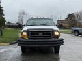 A 2000 Ford F-450 truck in white with visible front lights and a protective front bumper