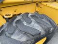 Close-up of a worn tire from a 2011 John Deere 310SJ 4x4 Wheel Loader showing deep treads and rugged surface designed for heavy-duty use