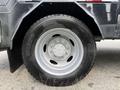 A close-up of the tire and wheel of a 2008 Ford F-450 SD showing a metallic silver wheel with a six-bolt pattern and a black tire marked DR310