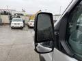 A 2019 Ford Transit with a close-up view of its side mirror showing raindrops on the surface