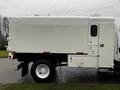 A white 2007 Freightliner M2 106 truck with a boxy cargo area and large black tires visible from the side