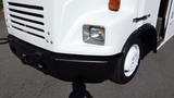 A white 2004 Freightliner MT45 with a distinctive front design featuring horizontal grille bars and a round headlight