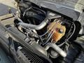 Engine compartment of a 2011 International 7500 featuring various metal pipes a coolant reservoir and additional mechanical components