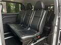 The interior of a 2018 Mercedes-Benz Metris showcasing three rows of black leather seats with seatbelts and adjustable headrests