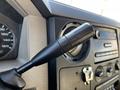 Close-up of the gear shift lever in a 2008 Ford F-450 SD showcasing a black knob and dashboard controls including a speedometer and radio dials