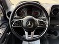 A 2019 Mercedes-Benz Sprinter steering wheel featuring controls for audio and cruise settings along with the Mercedes-Benz logo in the center