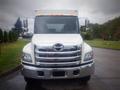 A front view of a 2014 Hino 308 with a white body and chrome accents on the grille and bumper