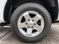 Close-up of a silver alloy wheel from a 2012 GMC Canyon with a prominent GMC logo and rugged tire tread visible