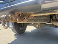 Close-up view of a rusty undercarriage of a 2010 Toyota Tacoma showing a tire and towing hitch