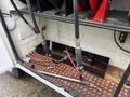 A 2000 Ford F-450 with hoses and connectors visible in the storage compartment