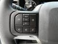 Close-up of the steering wheel controls of a 2024 Ford F-550 featuring buttons for volume cruise control and other functions