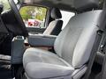 Interior view of a 2016 Ford F-550 showing the driver's side seat and center console with gray upholstery and storage compartment