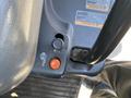 Close-up of the control panel of a 2018 Kubota RTV-X 1100 C showing a black button and a red button along with warning labels