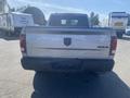 A silver 2021 RAM 1500 truck viewed from the rear with a visible tailgate and the 4x4 badge