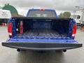 A blue 2019 RAM 1500 Classic with an open truck bed displaying a smooth surface and a fire extinguisher mounted on the side