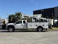 A 2016 Ford F-550 truck with a utility body and a mounted aerial lift equipped for maintenance and construction tasks