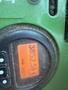 A John Deere 1585 Terrain Cut display showing a reading of 3852.5 with buttons and a dial in green and orange colors