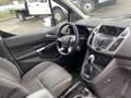 Interior of a 2017 Ford Transit Connect featuring a steering wheel dashboard with controls and a gear shift on the center console