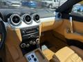 Interior of a 2005 Ferrari 612 Scaglietti featuring tan leather seats a central control panel with climate controls and circular air vents