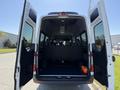 2023 Mercedes-Benz Sprinter with open rear doors revealing a spacious interior and several rows of seats arranged for passenger transport